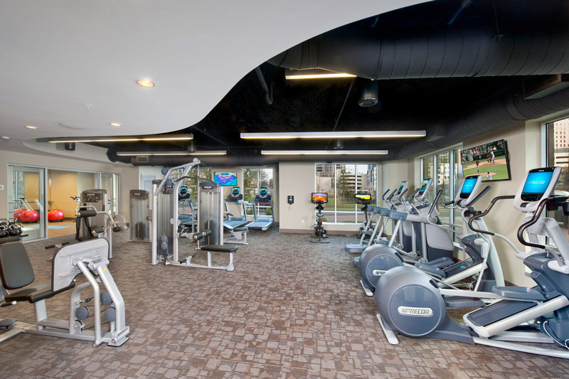 Fitness center with cardio machines like treadmills and elliptical machines, and strength training equipment