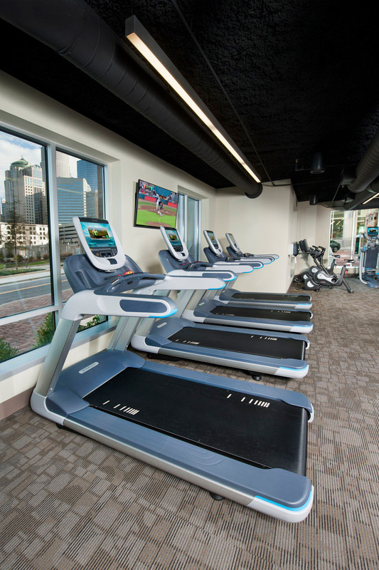 Treadmills in ftiness center with flast screen TV and large windows