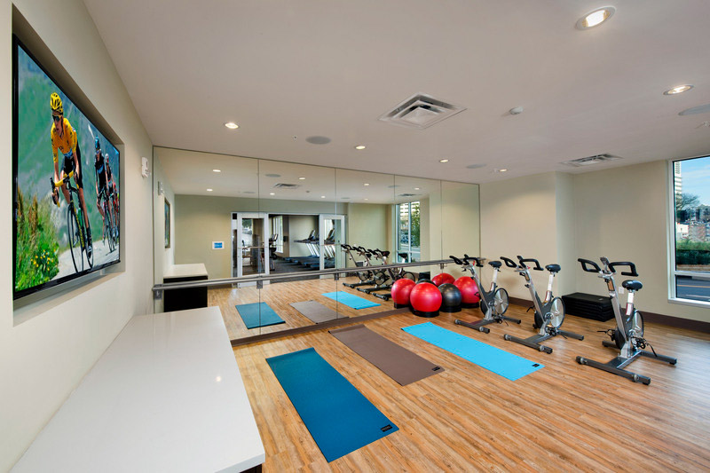 Fitness center with spin bikes, yoga mats, mirrored wall and flat screen TV