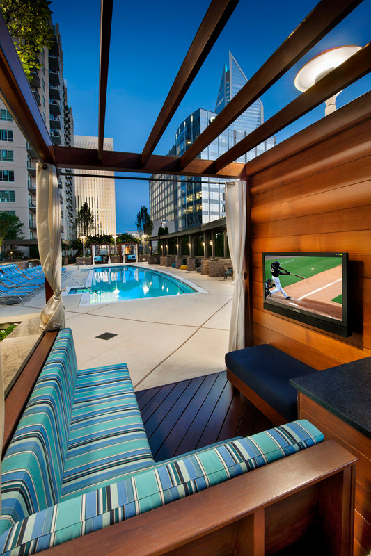 Detail view of pool cabana with plush bench seating and flat screen TV with views of the pool